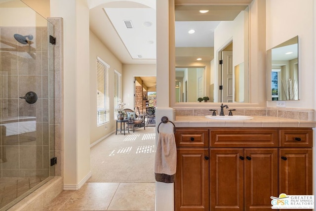 bathroom with tile patterned flooring, a shower with shower door, and vanity