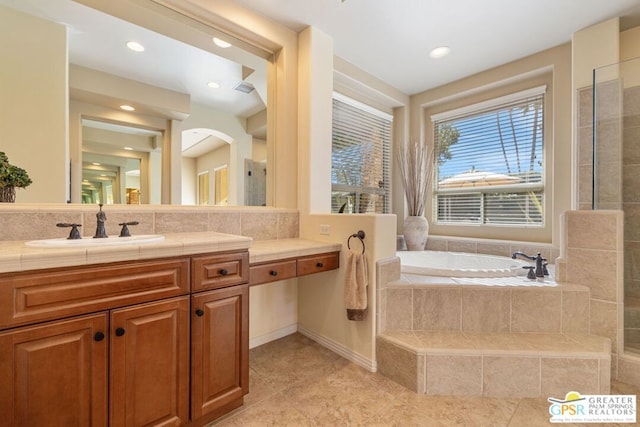 bathroom featuring tiled tub, tile patterned floors, and vanity