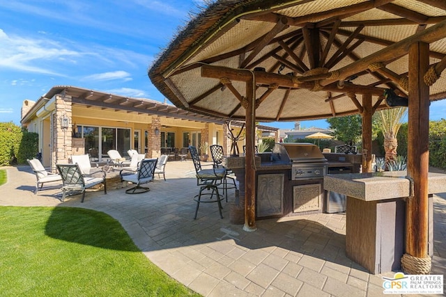 view of patio featuring exterior kitchen, an outdoor bar, a grill, and a gazebo