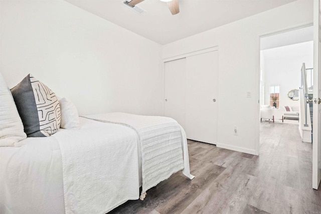 bedroom featuring wood-type flooring, a closet, and ceiling fan