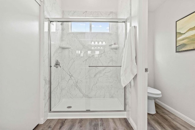 bathroom with hardwood / wood-style floors, an enclosed shower, and toilet