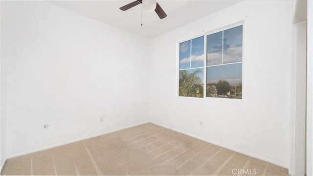 spare room featuring ceiling fan and light colored carpet