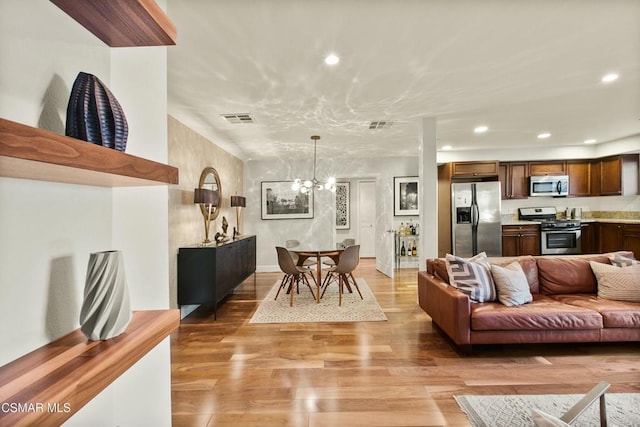 living room featuring light hardwood / wood-style flooring and an inviting chandelier