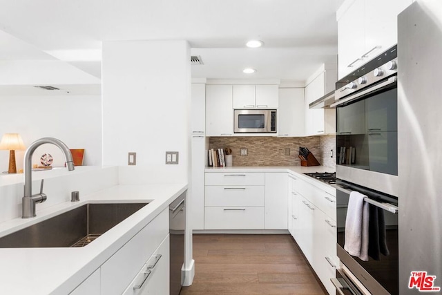 kitchen featuring sink, white cabinets, appliances with stainless steel finishes, and decorative backsplash