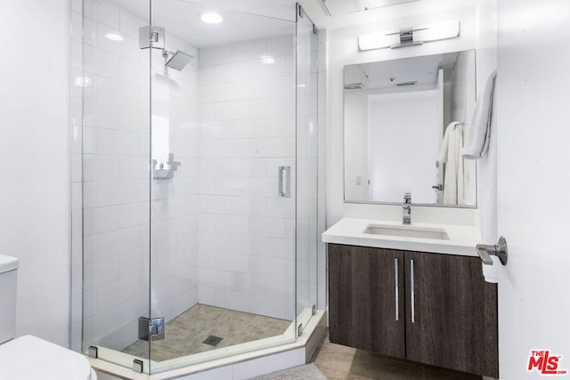 bathroom with vanity, toilet, and an enclosed shower