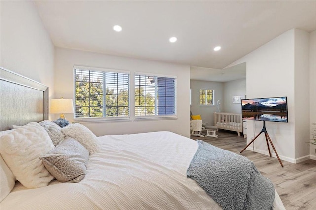 bedroom with hardwood / wood-style flooring and lofted ceiling