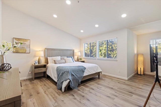 bedroom with light wood-type flooring and vaulted ceiling