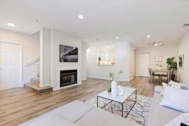 living room with track lighting and light hardwood / wood-style floors