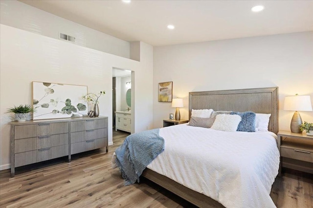 bedroom featuring wood-type flooring and ensuite bath