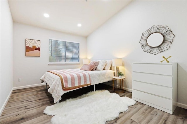 bedroom featuring wood-type flooring and vaulted ceiling