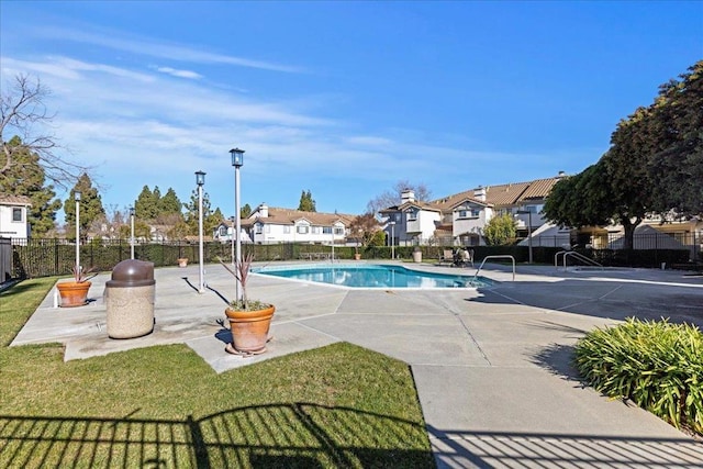 view of pool with a lawn