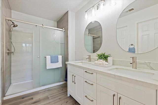 bathroom with vanity, wood-type flooring, and a shower with shower door