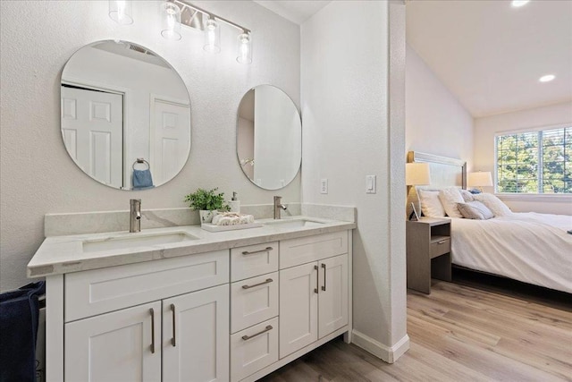 bathroom with hardwood / wood-style flooring, lofted ceiling, and vanity