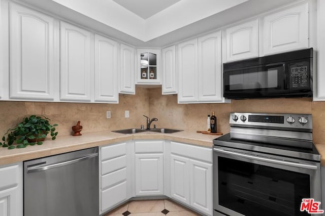 kitchen with sink, tasteful backsplash, white cabinetry, light tile patterned flooring, and stainless steel appliances