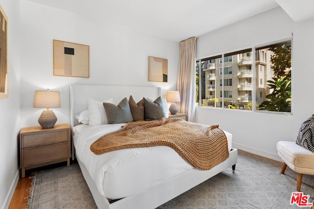 bedroom with multiple windows and hardwood / wood-style floors