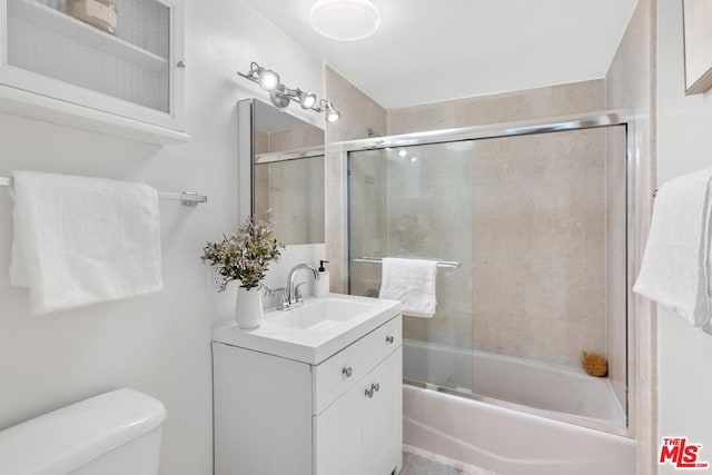 full bathroom featuring enclosed tub / shower combo, toilet, and vanity