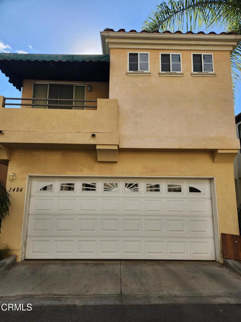 view of front of property with a garage and a balcony