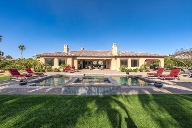 rear view of property with a pool with hot tub, a patio area, and a lawn