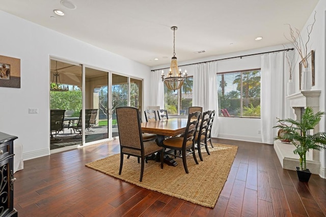 dining space with dark hardwood / wood-style flooring and a notable chandelier