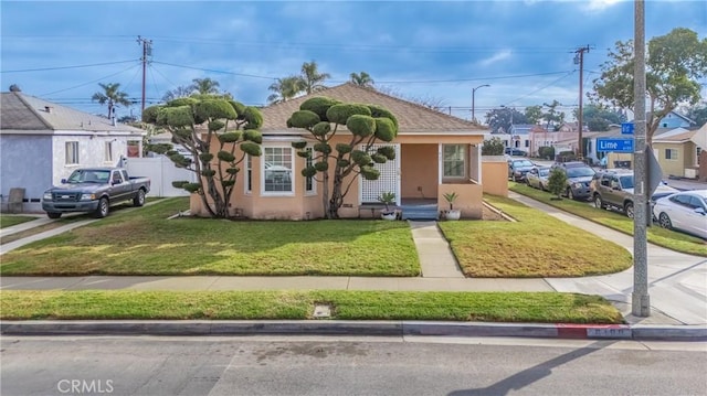 bungalow featuring a front lawn