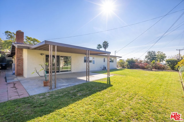 rear view of house with a patio area and a lawn