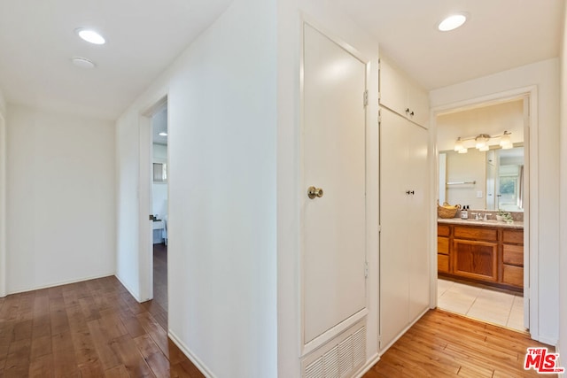 hallway featuring light hardwood / wood-style floors and sink