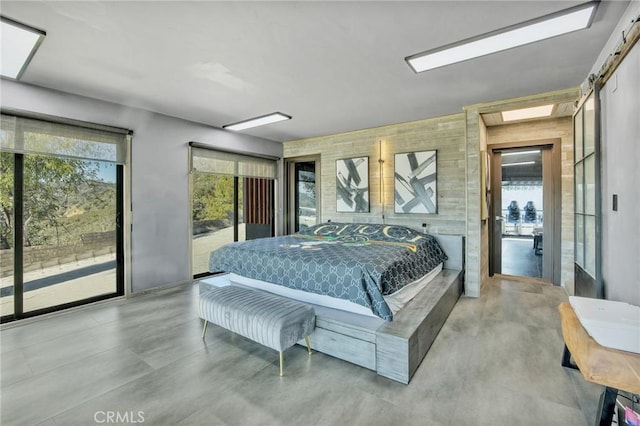 bedroom featuring access to exterior and concrete flooring