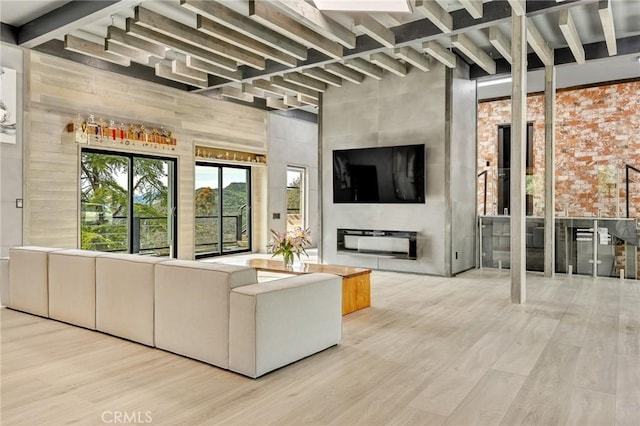 unfurnished living room featuring a fireplace, light hardwood / wood-style floors, and wooden walls