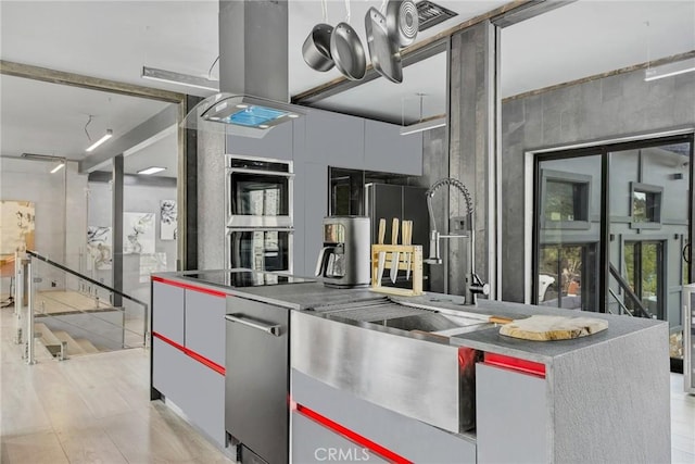 kitchen featuring black electric stovetop, light hardwood / wood-style flooring, and double oven