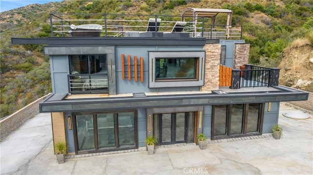 rear view of property with a balcony and a patio area