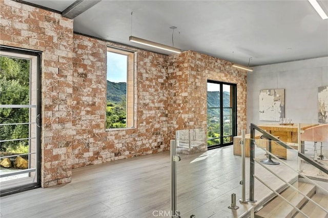 interior space featuring wood-type flooring and brick wall