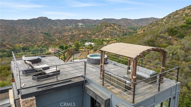 exterior space with a mountain view, central AC, and a hot tub