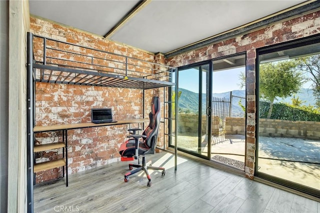 doorway featuring a mountain view, brick wall, and wood-type flooring