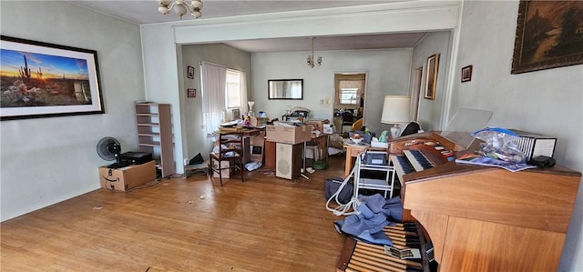 office with hardwood / wood-style floors and a chandelier