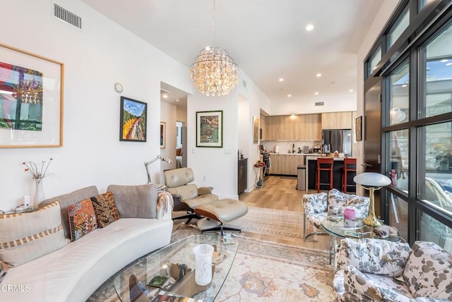 living room featuring light wood-type flooring and a chandelier