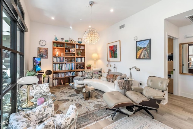 living area with an inviting chandelier and light wood-type flooring