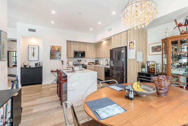 dining room with a notable chandelier, light hardwood / wood-style floors, and sink