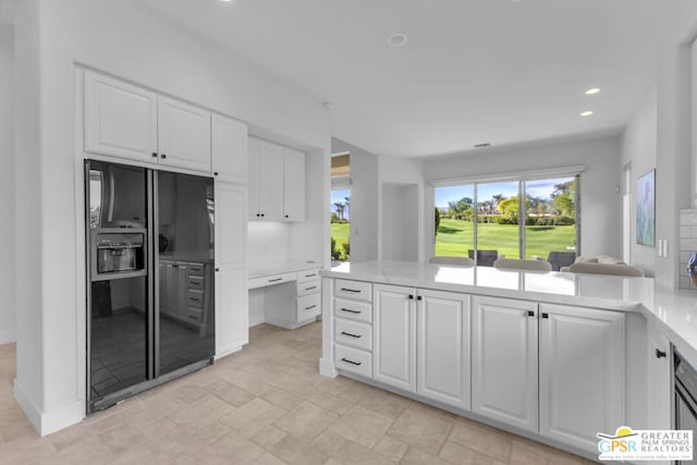 kitchen with white cabinets and black fridge with ice dispenser