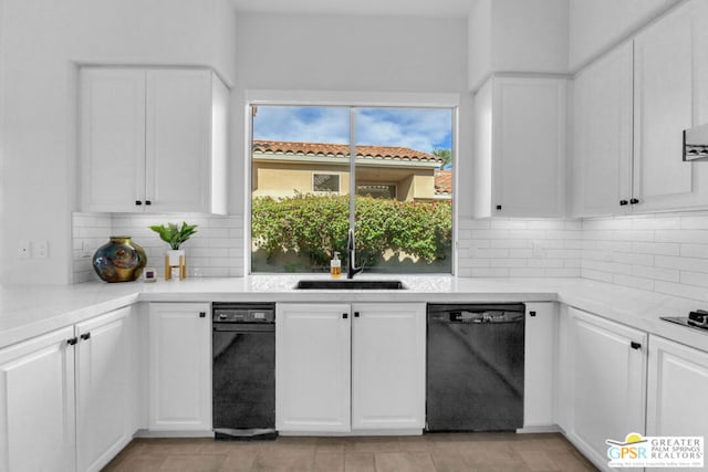 kitchen featuring white cabinets, black dishwasher, sink, and tasteful backsplash