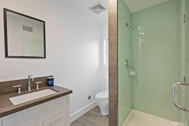 bathroom with vanity, wood-type flooring, toilet, and walk in shower