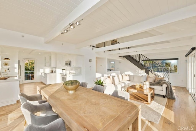 dining area with beamed ceiling, track lighting, wood ceiling, and light hardwood / wood-style floors