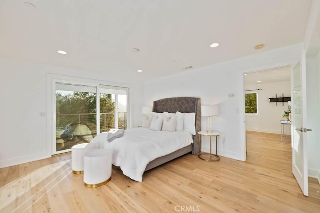 bedroom featuring multiple windows, hardwood / wood-style floors, and access to exterior