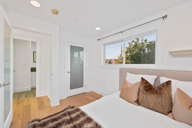 bedroom featuring ensuite bathroom and light hardwood / wood-style flooring