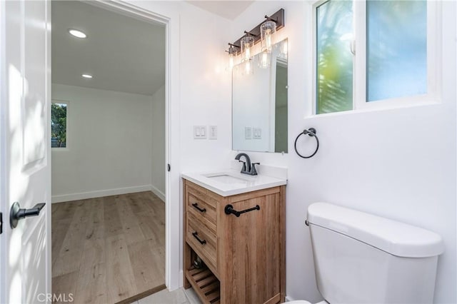 bathroom with wood-type flooring, toilet, and vanity