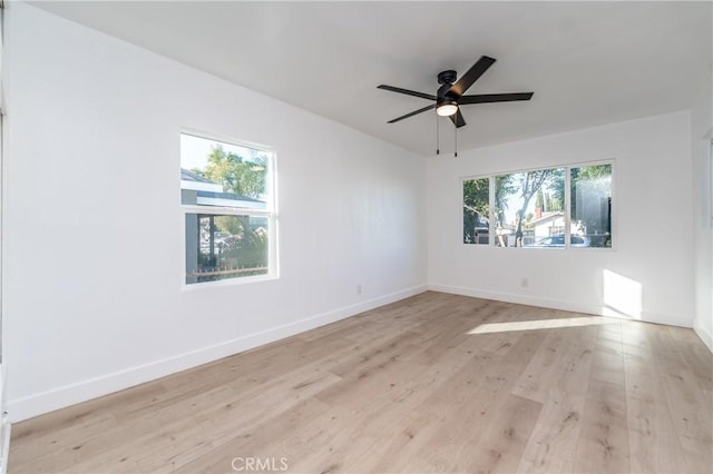 unfurnished room with ceiling fan, a wealth of natural light, and light hardwood / wood-style flooring