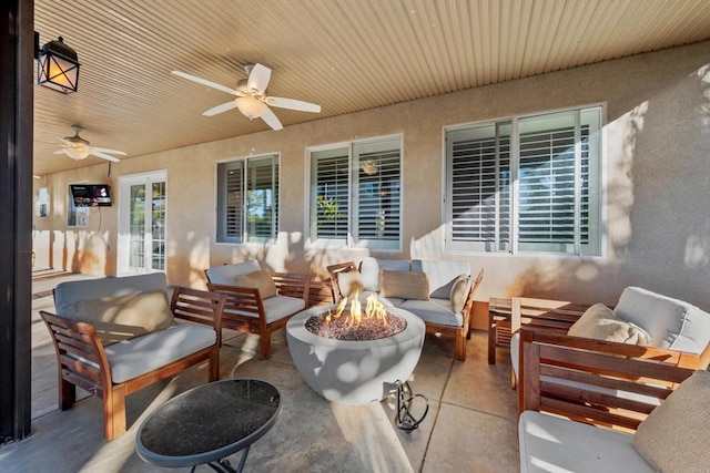 view of patio / terrace with ceiling fan and an outdoor living space with a fire pit