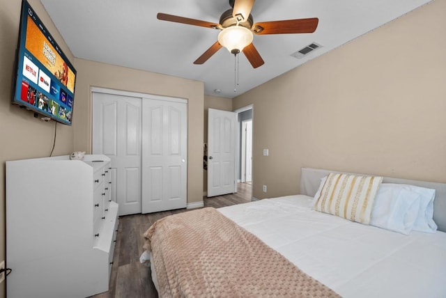 bedroom featuring dark wood-type flooring, a closet, and ceiling fan