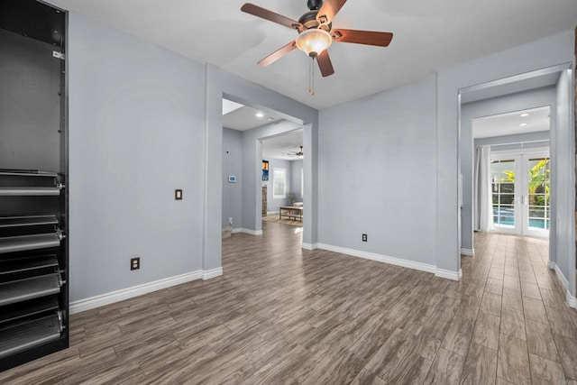 unfurnished room with ceiling fan, french doors, and wood-type flooring