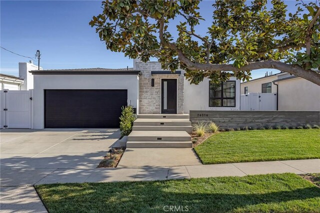 contemporary house with a front yard and a garage