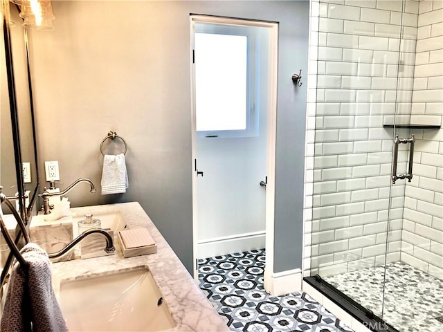 bathroom featuring a shower with shower door and vanity